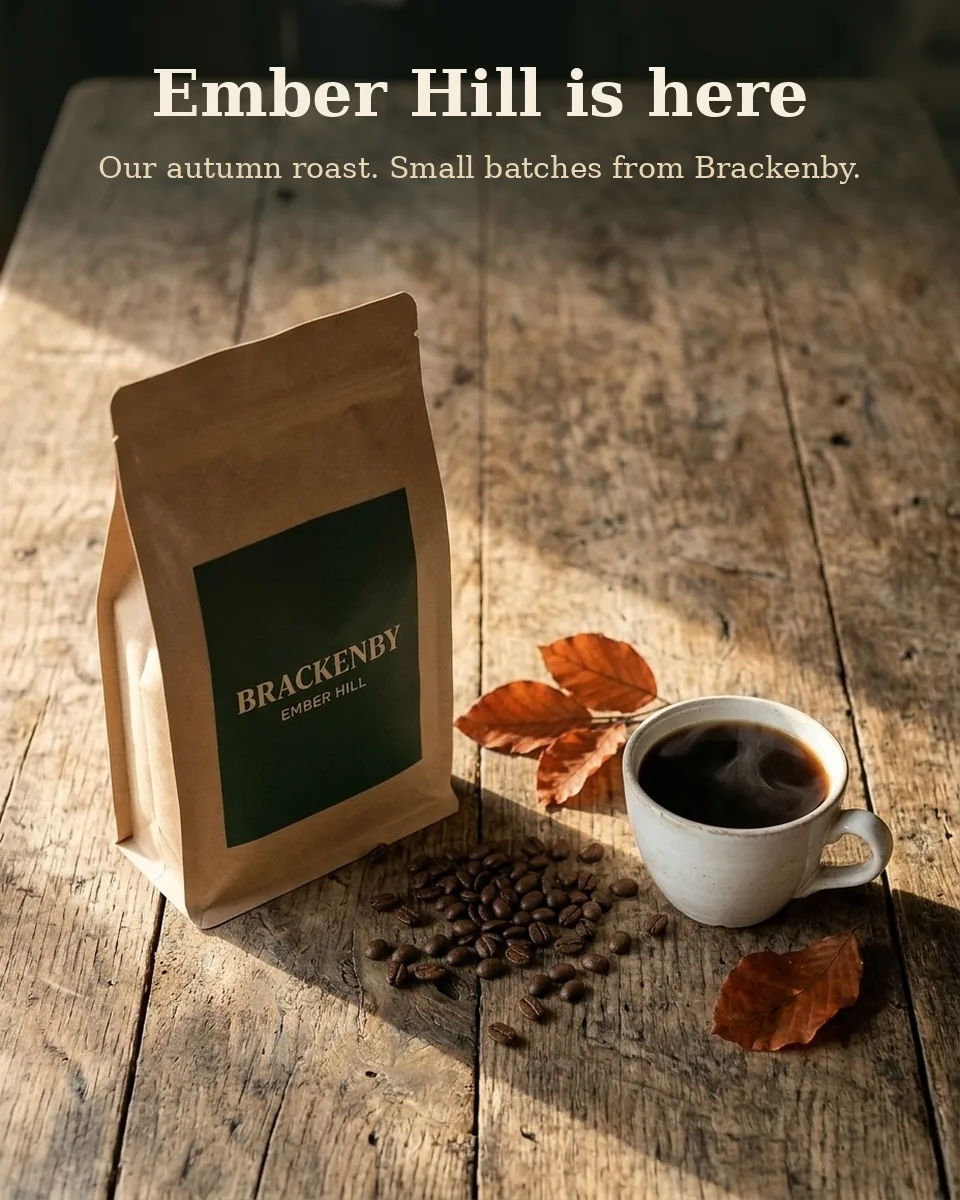 Overhead AI photo of the Brackenby coffee bag and a cup of coffee on an oak table with the headline Ember Hill is here added at the top